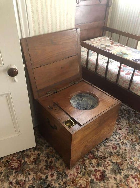 जुन्या पद्धतीचा बेड शेजारील कमोड